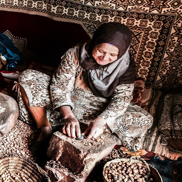 Woman grinding grain on a stone pestle and mortar